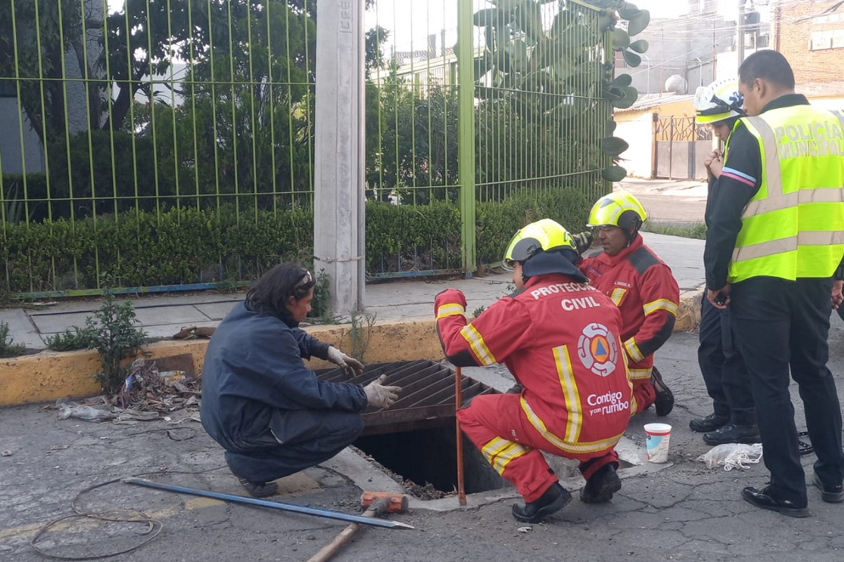 FOTOS Vecinos rescatan a lomito atrapado en una alcantarilla 